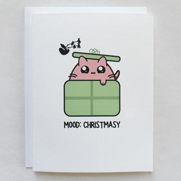 cat in a gift box with mood christmasy words